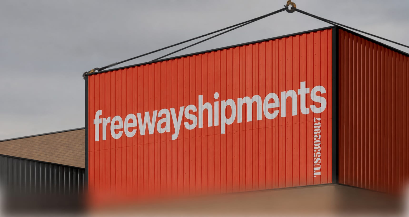 A Freeway Shipments freight container being lifted by a crane
